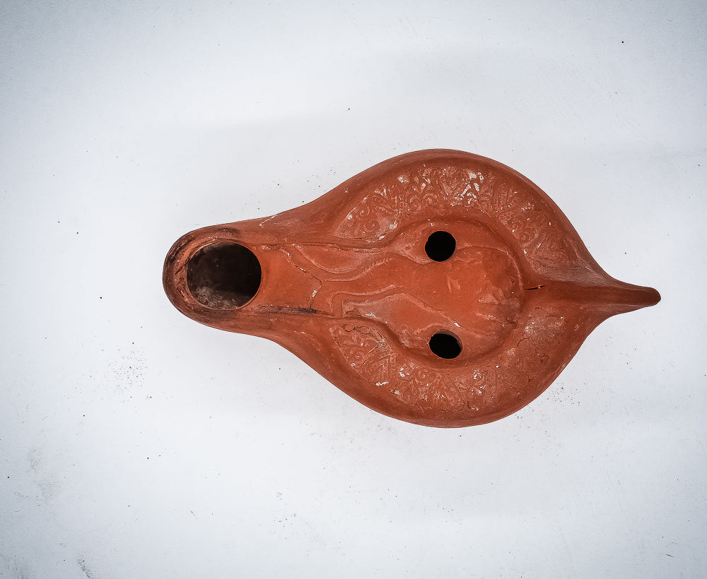 A NORTH-AFRICAN RED TERRACOTTA OIL LAMP DEPICTING A LION