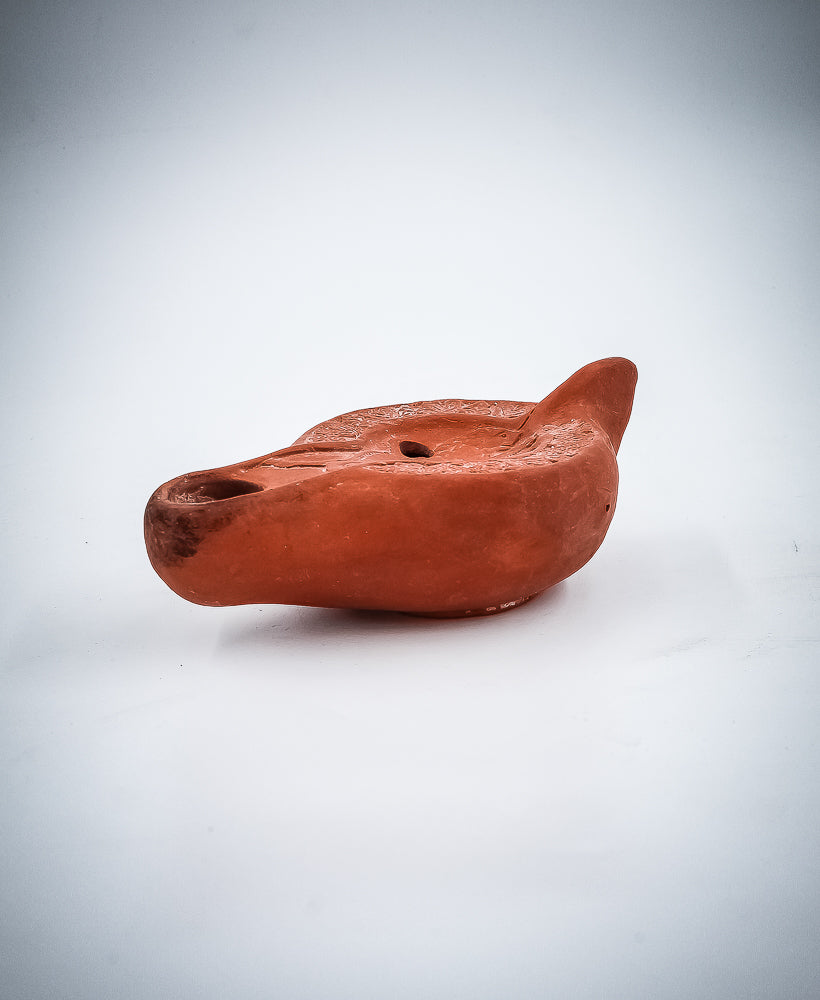 A NORTH-AFRICAN RED TERRACOTTA OIL LAMP DEPICTING A LION