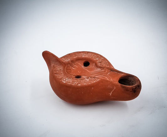 A NORTH-AFRICAN RED TERRACOTTA OIL LAMP DEPICTING A LION