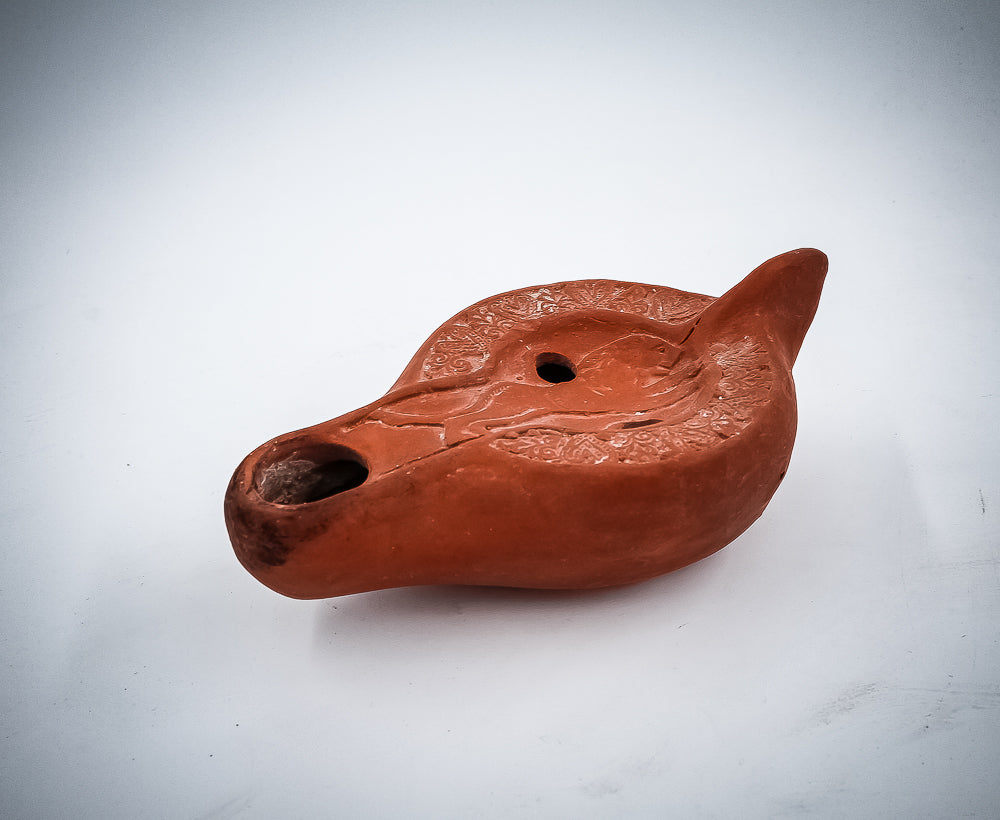A NORTH-AFRICAN RED TERRACOTTA OIL LAMP DEPICTING A LION